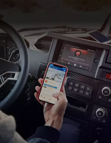 נהג משאית מביט בטלפון החכם שלו